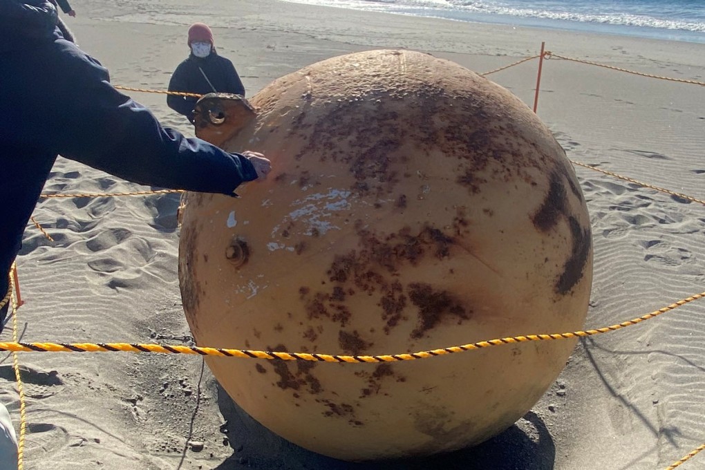 The mystery metal sphere pictured on a beach in Hamamatsu, Japan, on Wednesday. Photo: Twitter/@XMiS10C4M6QthSG via Reuters