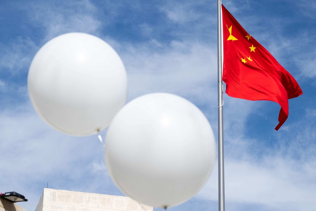 Two white balloons float near the Chinese flag as part of an activist’s protest outside the Chinese embassy in Washington on February 15. Photo: AFP