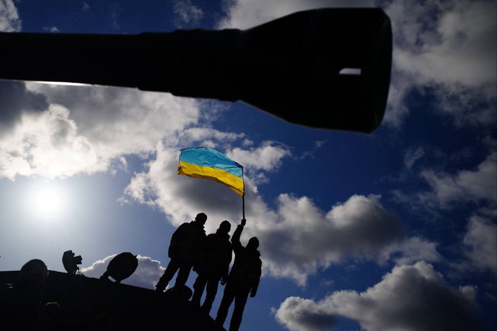 Ukrainian soldiers who are undergoing training at Bovington Camp, a British Army military base, wave a Ukrainian flag on Wednesday. Photo: AFP