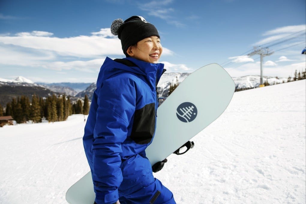 Patti Zhou carries her snowboard up Copper Mountain in Colorado. Photo: AP