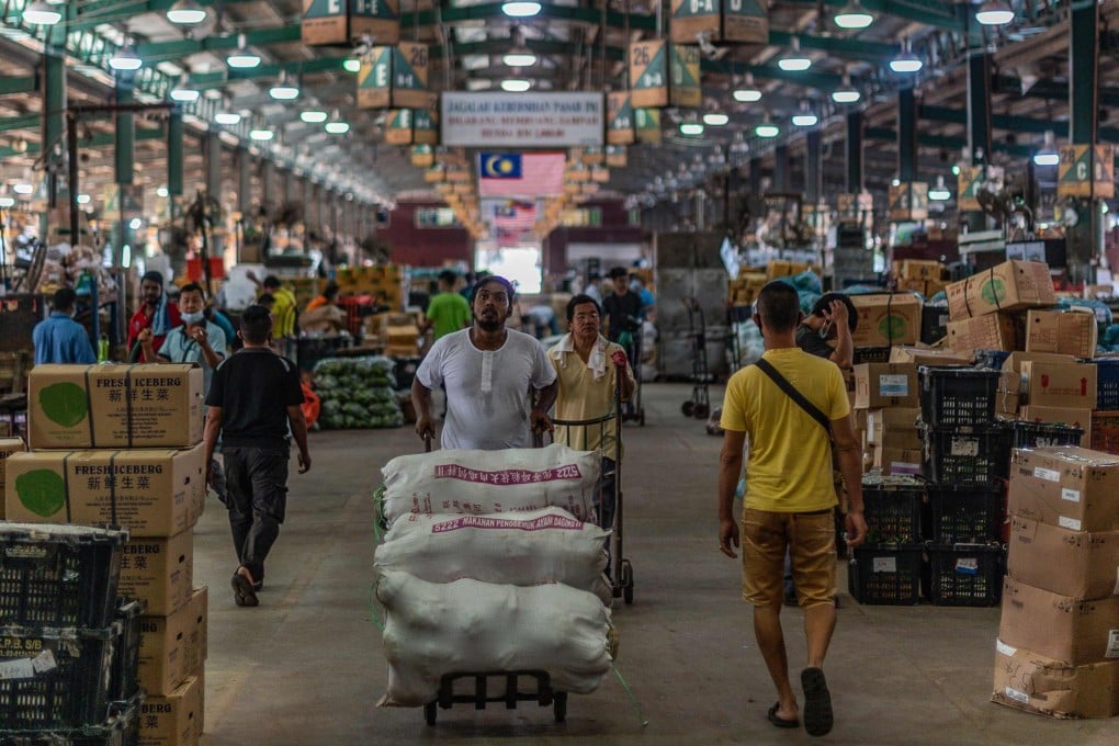 A worker pushes goods at a wholesale market in Kuala Lumpur. Photo: AFP