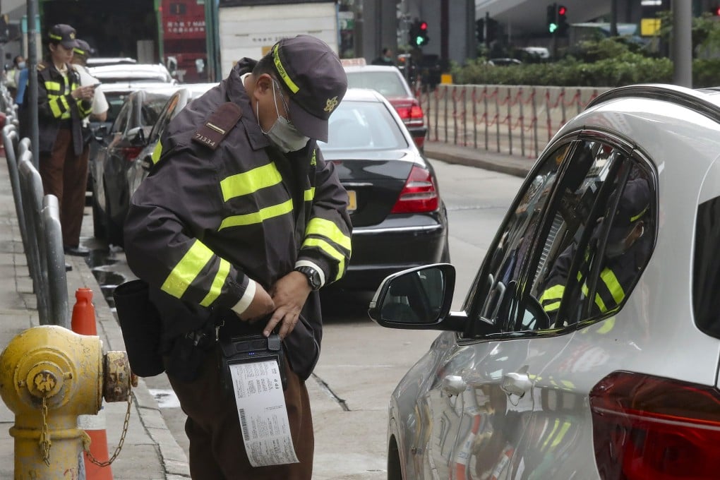 A traffic warden hands out tickets to illegally parked cars in Sheung Wan. Photo: K. Y. Cheng