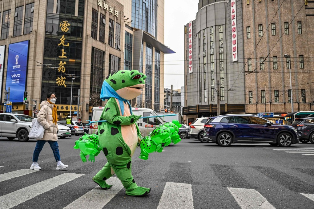 A person dressed in a costume walks on a street as they sell inflatable plastic figures in the Jingan district in Shanghai on February 22. The effects of China’s reopening and its associated economic impulse are expected to drive a surge in domestic demand that will lift the Chinese and global economies. Photo: AFP