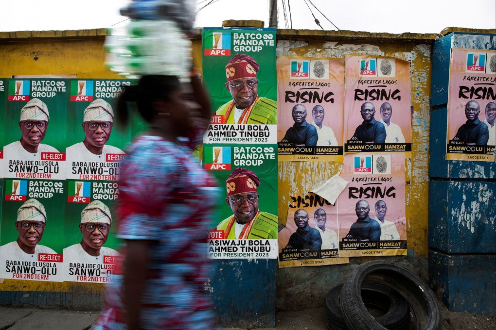 A woman walks past election posters of APC party candidates including presidential hopeful Bola Ahmed Tinubu in Lagos, Nigeria. Photo: Reuters