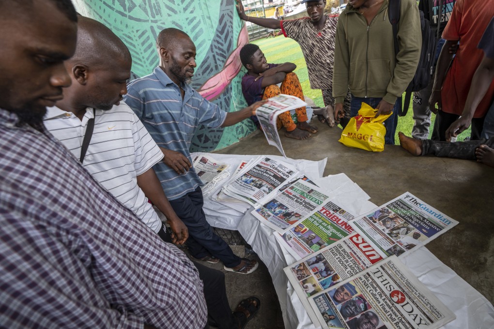 People discuss Saturday’s election as they look at newspapers in Lagos, Nigeria, on Sunday. Photo: AP