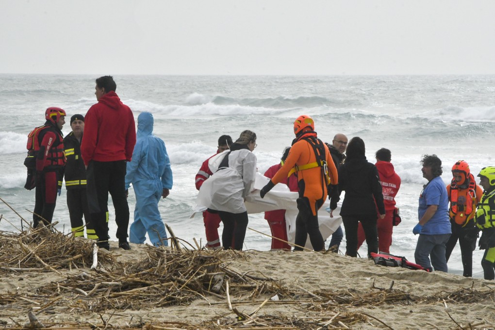 Rescuers recover a body on a beach in southern Italy on Sunday after a migrant boat broke apart in rough seas, killing dozens. Photo: AP