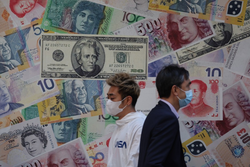 People walk past currency notes displayed outside a currency exchange in Sheung Wan, Hong Kong, in October last year. China’s renminbi could be a clear candidate for investors looking for attractive short dollar currency plays. Photo: Yik Yeung-man