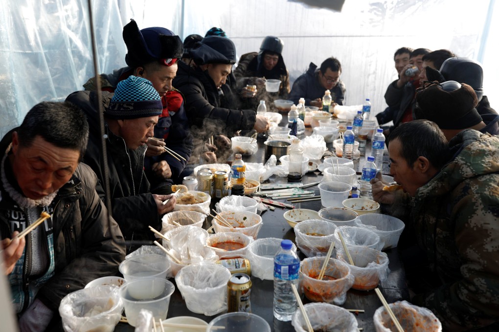 Workers eat lunch near the the site of the Harbin International Ice and Snow Festival, before its opening in Harbin, China, on December 17, 2020. Photo: Reuters