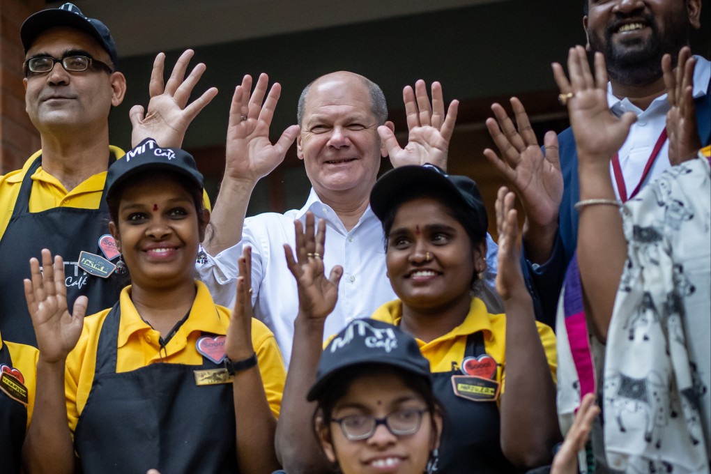 German Chancellor Olaf Scholz, centre, poses for a picture with employees of the Mitti Cafe in Begaluru, India on Sunday. Photo: dpa