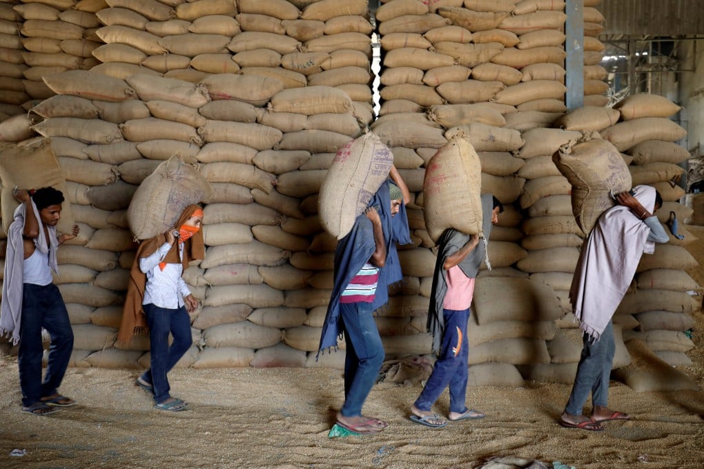 Workers carry sacks of wheat for sifting at a grain mill on the outskirts of Ahmedabad, India, last year. Photo: Reuters