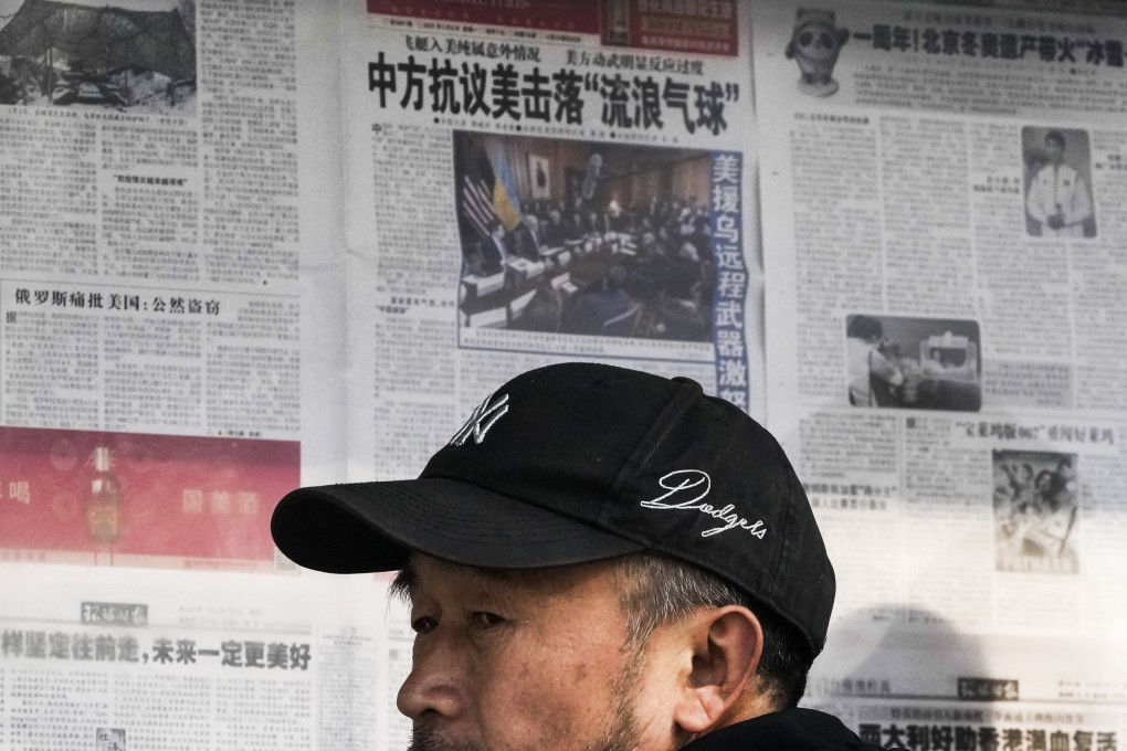 A man reacts after reading a newspaper headline reporting on the US-China balloon incident at a stand in Beijing on February 6. Photo: AP