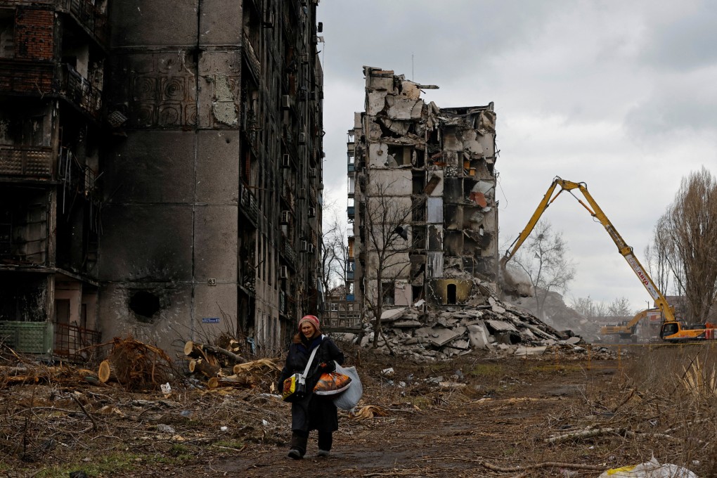 A woman walks past destroyed apartment blocks in her neighbourhood in Mariupol in Russian-controlled Ukraine, on February 15. Photo: Reuters