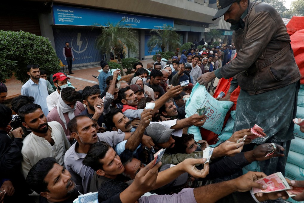 Men reach out to buy subsidised flour sacks from a truck in Karachi, Pakistan. Photo: Reuters/File
