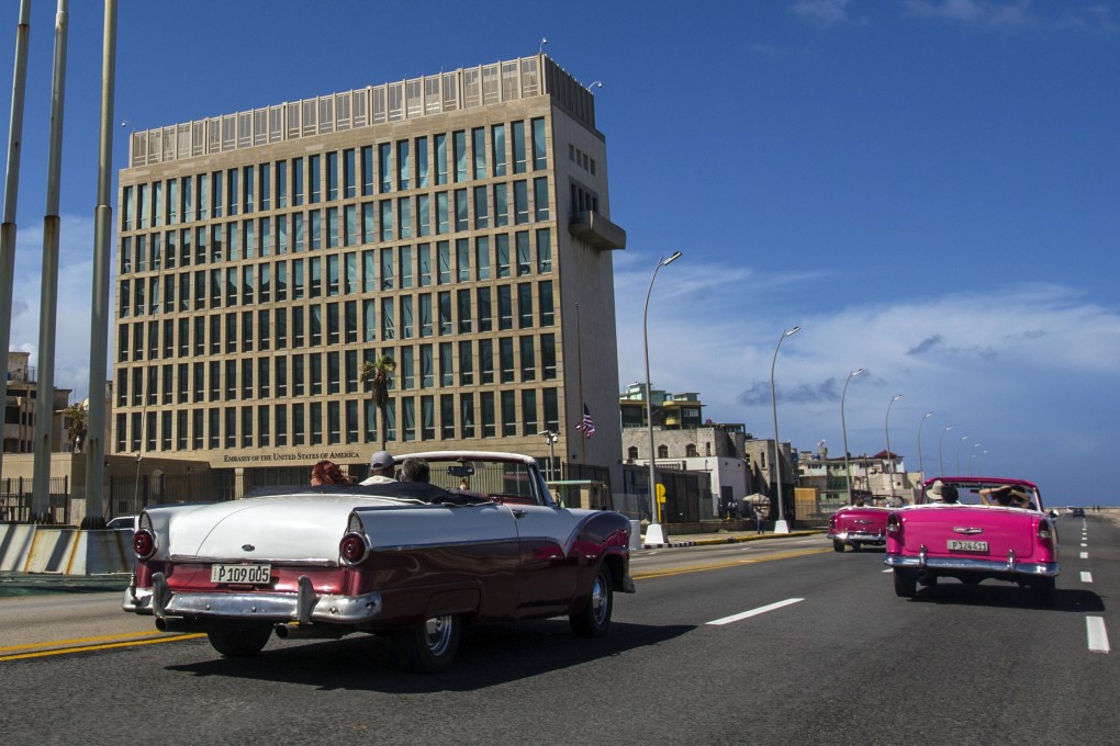Tourists ride classic convertible cars past the US embassy in Havana, where the first “Havana Syndrome” cases were reported. Photo: AP