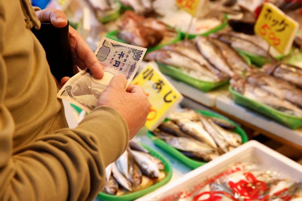 A man buys fish at a market in Tokyo on Friday. Photo: Reuters
