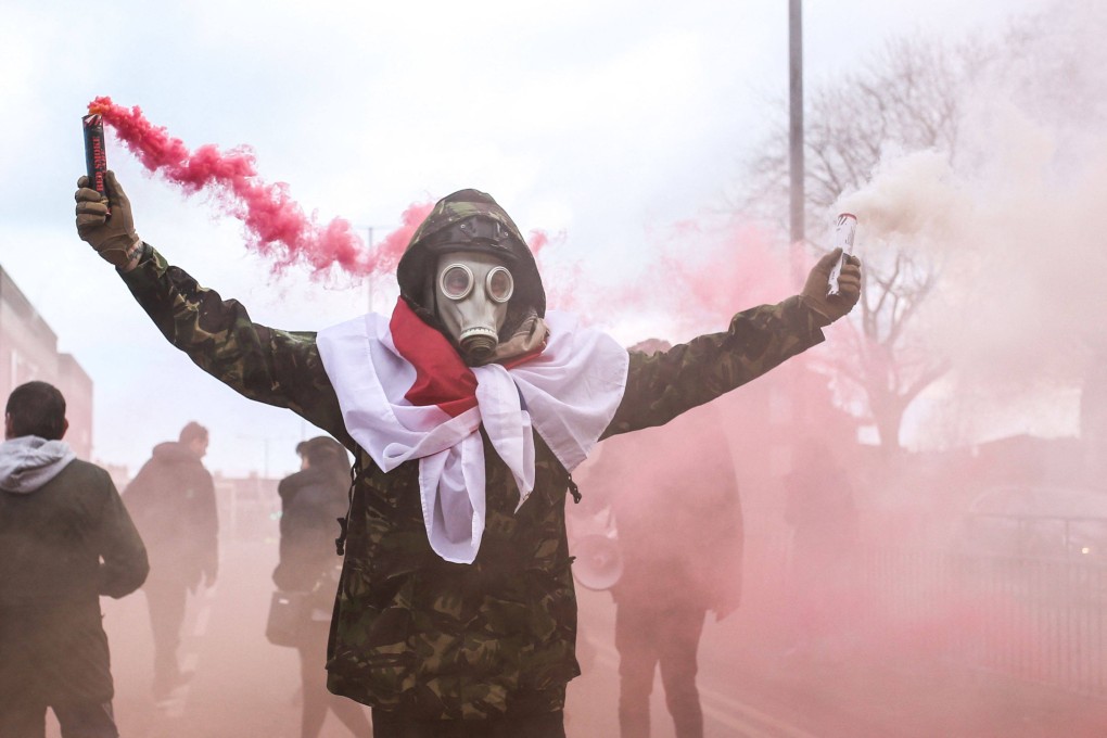 A man holds smoke flares during an anti-immigration march in Dover on the south-east coast of England on Saturday. More than 45,000 migrants crossed the Channel to the UK from mainland Europe in 2022, surpassing the previous year’s record by more than 17,000. Photo: AFP