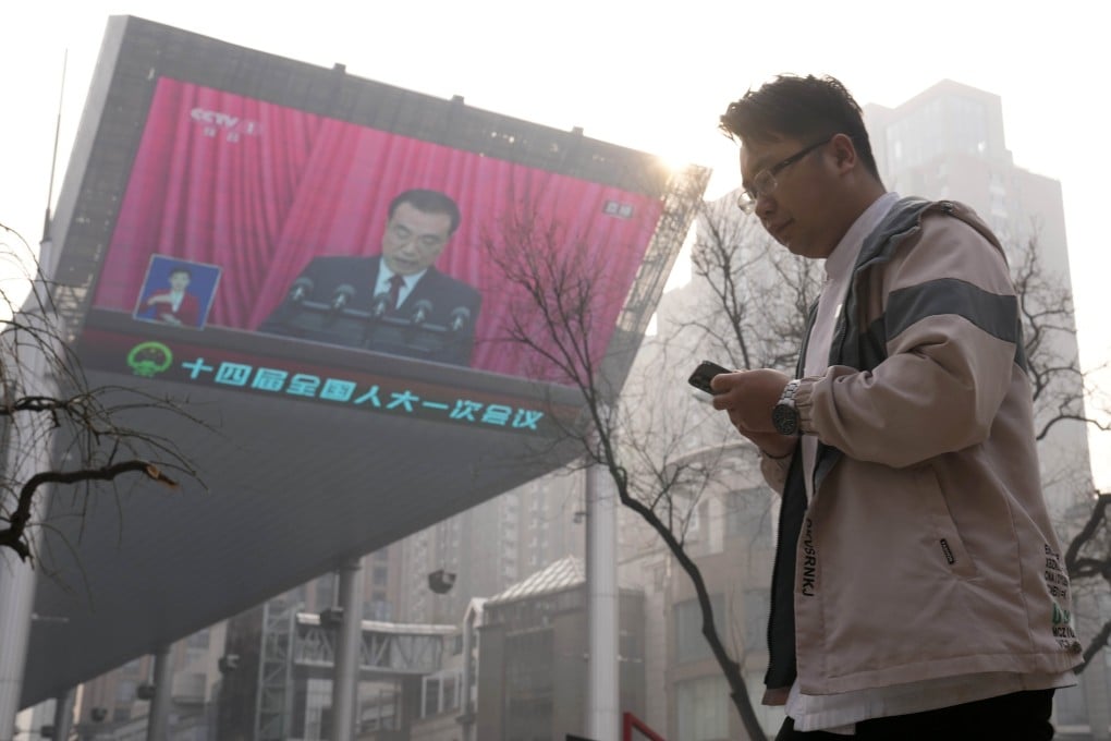 Premier Li Keqiang is seen speaking on a large screen in Beijing on Sunday during the opening session of the National People’s Congress. Photo: AP