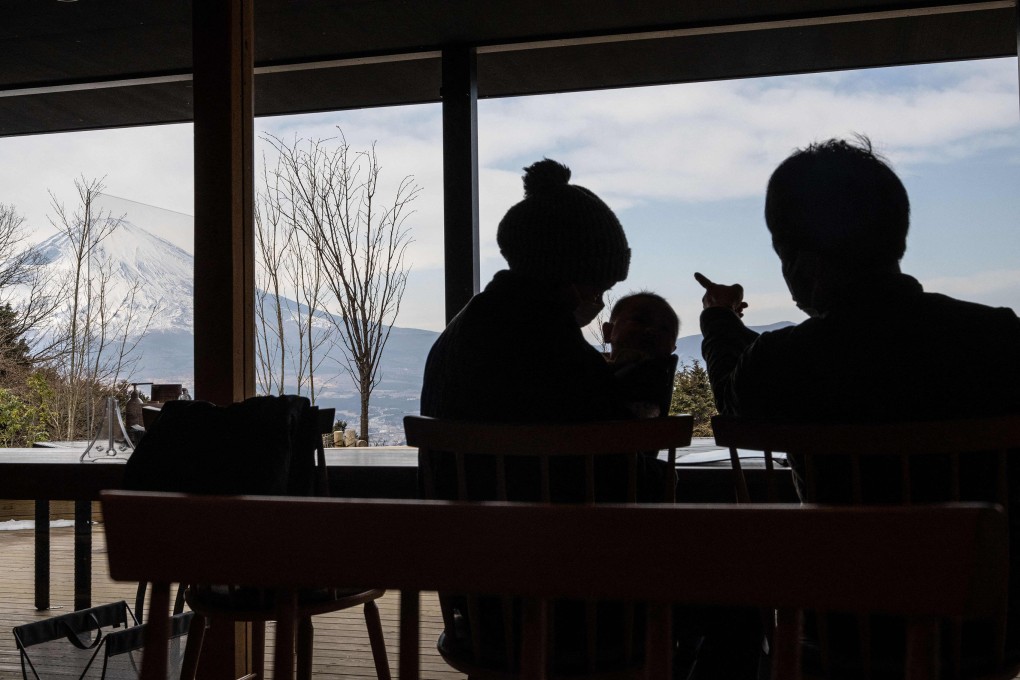 A couple with a child look at Mount Fuji from a table in a cafe. Japan’s population has fallen to 124.6 million from a peak of just over 128 million in 2008, and the pace of decline is increasing. Photo: AFP/Getty Images/TNS