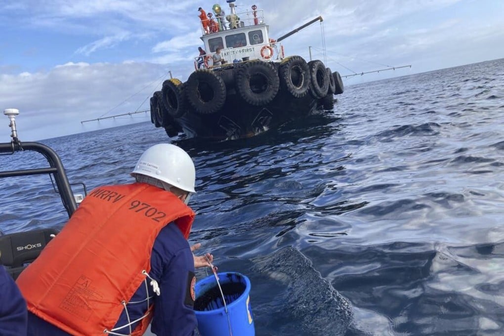 A coast guard personnel collects water samples from an oil spill in the waters off Naujan, Oriental Mindoro, central Philippines, on March 2, 2023. Photo: via AP