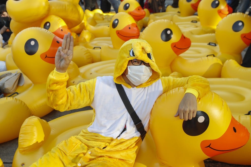 A protester flashes the three-finger protest gesture while wearing an outfit of a yellow duck during an anti-government rally in Bangkok in 2020. Photo: AP