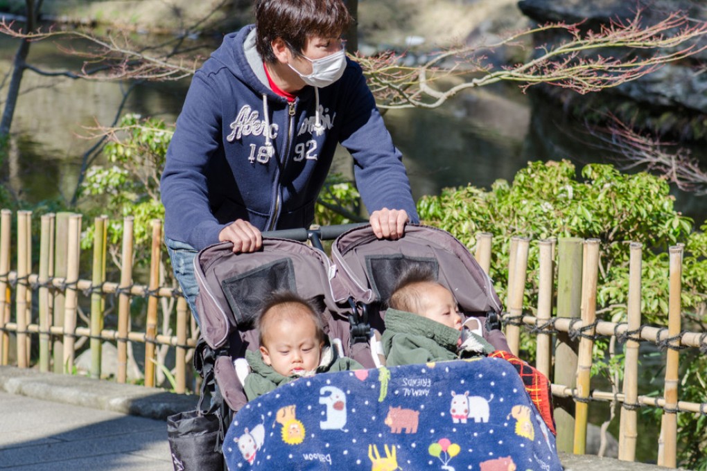 A young Japanese father pushes his twin babies in a stroller. Births in Japan hit an all-time low last year. Photo: Shutterstock