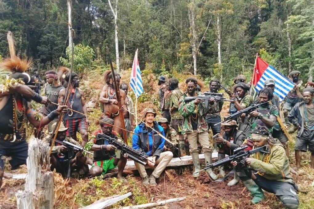 A man who is identified as Philip Mehrtens, the kidnapped New Zealand pilot, sits among separatist fighters in Indonesia’s Papua region. Photo: Reuters