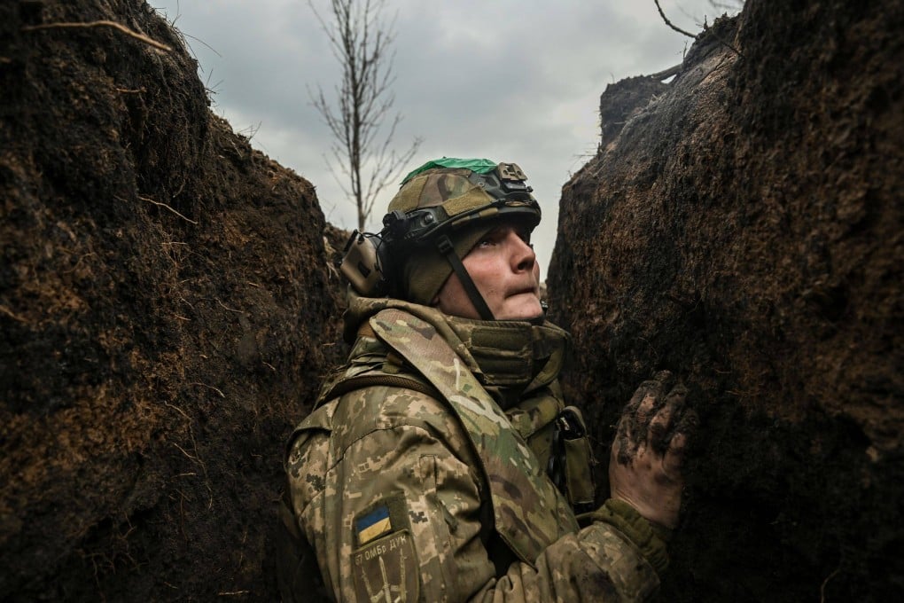 A Ukrainian serviceman takes cover in a trench during shelling near the city of Bakhmut. Photo: AFP