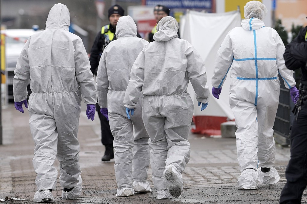 Forensic experts walk to a Jehovah’s Witness building in Hamburg, Germany, where multiple people were killed and wounded. Photo: AP