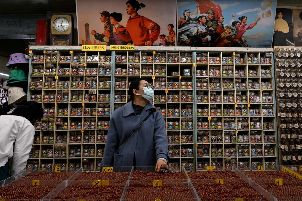 People shop at a store at the Nanluoguxiang alley in Beijing on March 3. Chinese economic officials have expressed confidence the country can meet this year’s 5 per cent growth target by generating 12 million new jobs and encouraging consumer spending following the end of anti-pandemic controls that kept millions of people at home. Photo: AFP