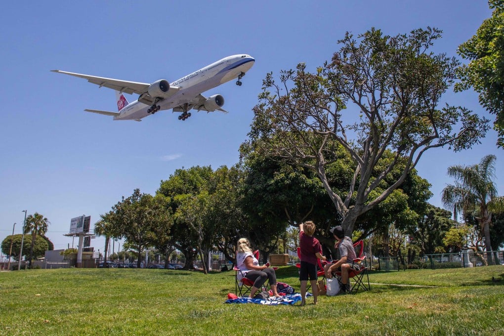 A family watches a China Airlines plane landing at Los Angeles International Airport in May 2020. Photo: AFP