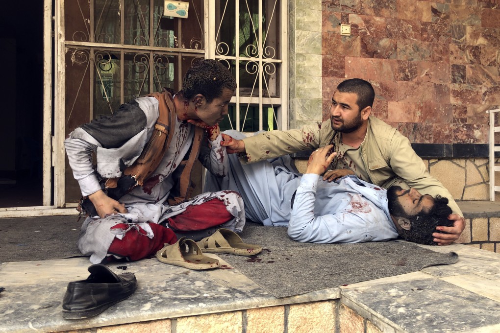 An injured man lies down after a bomb blast in Mazar-i-Sharif, the capital city of Balkh province, in northern Afghanistan on Saturday. Photo: AP