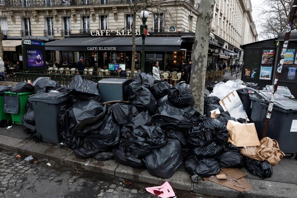 People walk in a street where garbage cans are overflowing, as garbage has not been collected, in Paris. Photo: Reuters