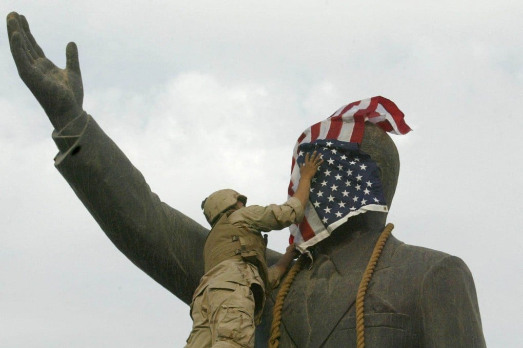 A US Marine covers the face of Saddam Hussein’s statue with the US flag in Baghdad’s al-Fardous square on April 9, 2003. File photo: AFP