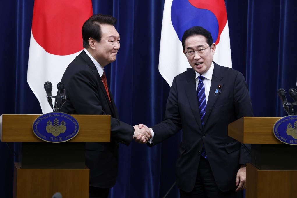 South Korean President Yoon Suk Yeol, left, and Japanese Prime Minister Fumio Kishida shake hands during a joint press conference in Tokyo on Thursday. Photo: via AP