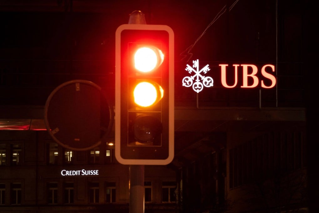 A sign of Credit Suisse bank is seen behind a sign of Swiss banking giant UBS in Zurich on Saturday. Photo: AFP