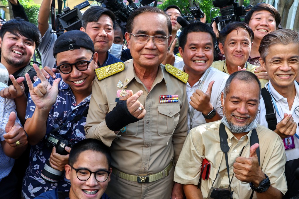 Thailand’s Prime Minister Prayuth Chan-ocha poses with members of the media after the king endorsed a decree to dissolve parliament. Photo: Reuters