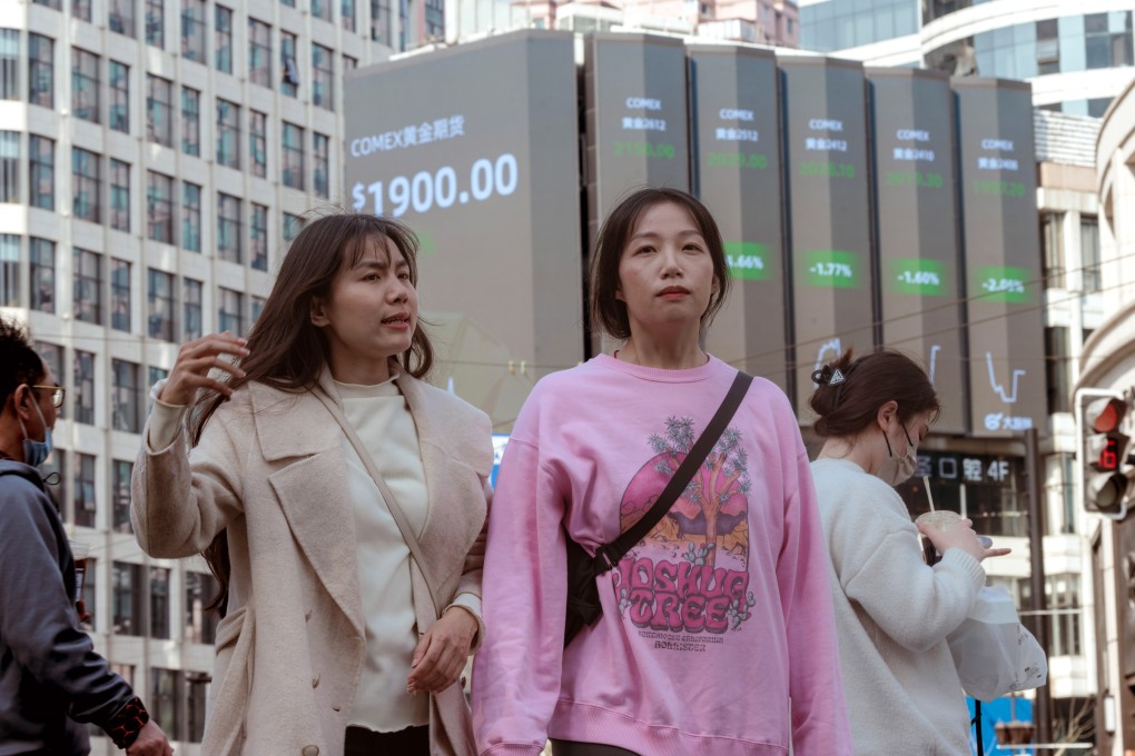 People in Shanghai pass a screen showing stock exchange data on March 15. Photo: EPA-EFE