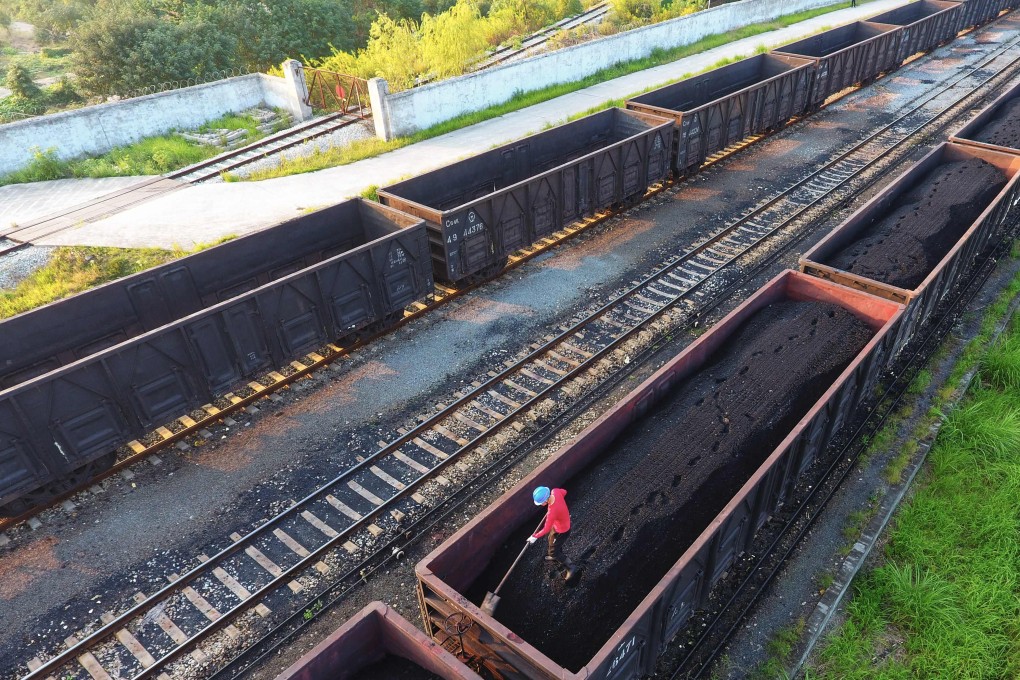 A photo taken on October 24, 2021, shows a worker leveling coal on a carrier in Jiujiang, in China’s central Jiangxi province. Photo: AFP