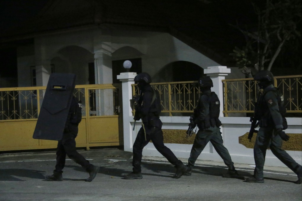 Police commandos approach a house in Phetchaburi province, southwest of Bangkok, Thailand, where a gunman shot three people to death. Photo: AP