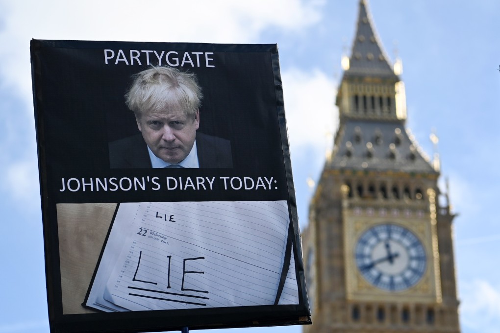 A protester’s sign is seen outside parliament in London on Wednesday as former British PM Boris Johnson gives evidence to MPs investigating Covid-19 Partygate accusations. Photo: EPA-EFE
