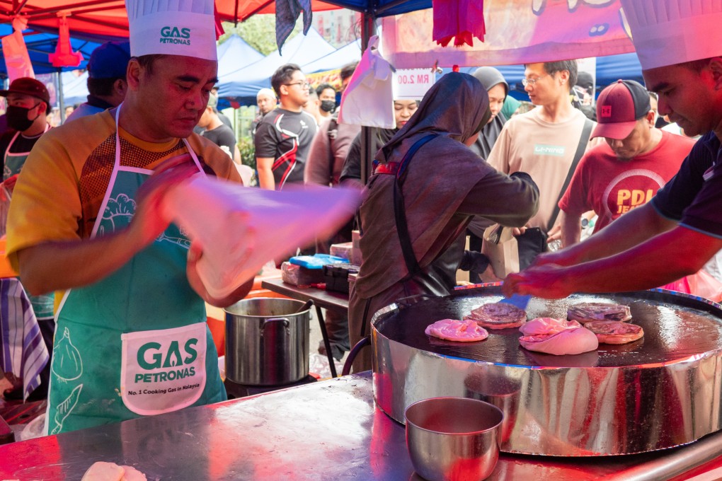 A seller at the Kampung Baru Ramadan bazaar in Kuala Lumpur prepares roti canai. Photo: Hadi Azmi
