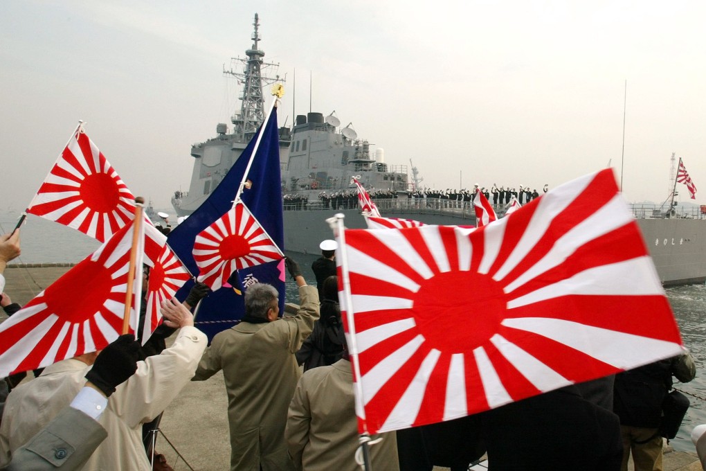 People wave flags at a Japanese guided missile destroyer equipped with an Aegis detection system. Photo: Reuters