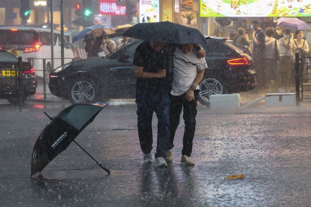 People try to shelter from the heavy rain in Tsim Sha Tsui. Photo: Edmond So