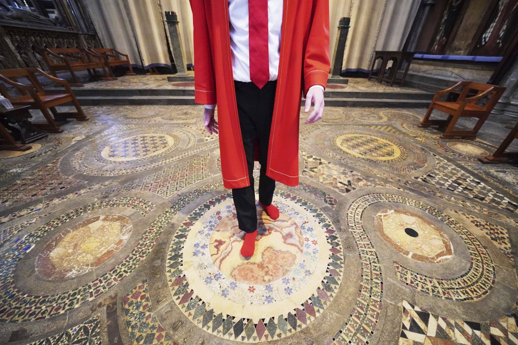 Abbey Marshal Howard Berry stands on the centre of the Cosmati pavement in Westminster Abbey, London on Thursday. Photo: PA via AP