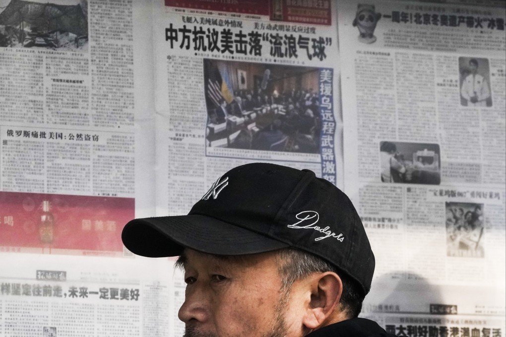 A man reacts after reading a newspaper report on China’s protest against the US shooting down a Chinese balloon at a news-stand in Beijing on February 6. Photo: AP