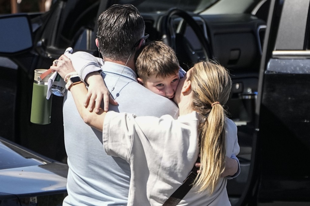 A woman kisses a child at the reunification centre at the Woodmont Baptist church after a school shooting in Nashville, Tennessee, on Monday. Photo: AP