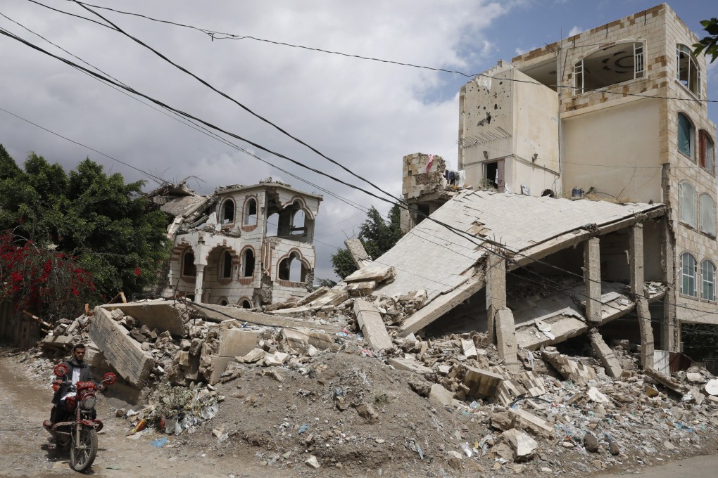 A Yemeni man rides a motorcycle past the rubble of buildings destroyed by Saudi-led coalition airstrikes in Sana’a, Yemen, on March 14. The two warring parties, the Yemeni government and the Houthis, have been militarily and politically backed by Saudi Arabia and Iran since 2015. Photo: EPA-EFE