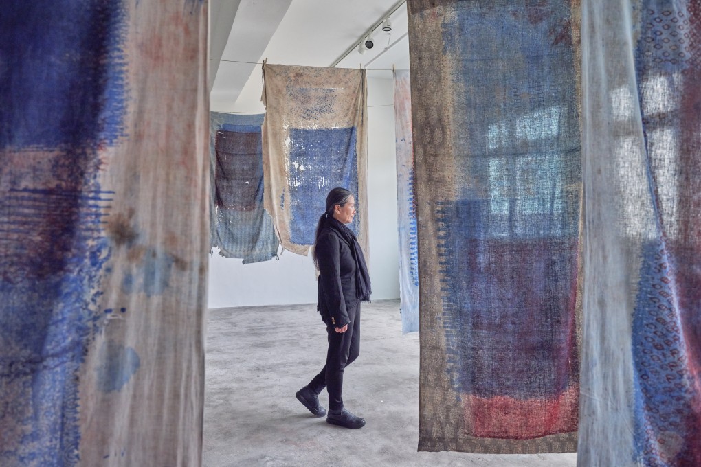 South Korean artist Kimsooja walks amid her work “Thread Routes – Chapter III (block printing table covers)”, part of her exhibition “Topography of Body” at Axel Vervoordt Gallery in Wong Chuk Hang, Hong Kong. Photo: Kitmin Lee