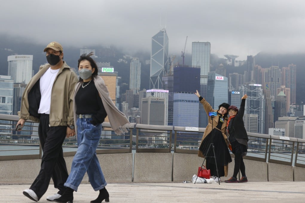 People take photos on the Tsim Sha Tsui waterfront on January 10. The tourism industry has traditionally been an important income source for Hong Kong. Photo: May Tse