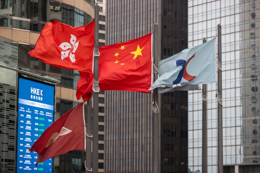 The People’s Republic of China flag (centre) and the Hong Kong SAR flag (left) fly outside Exchange Square, the building housing the stock exchange in Hong Kong,  on March 29, 2023. Photo: EPA-EFE